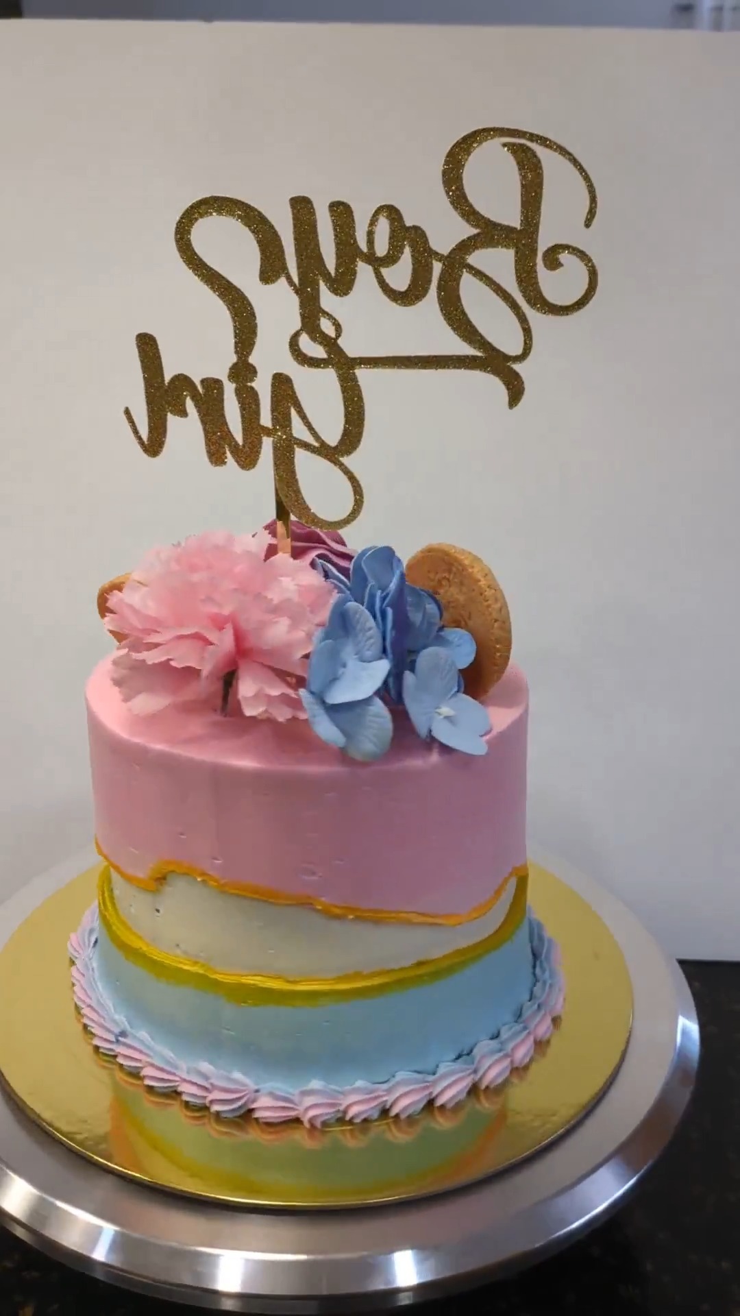 Gender reveal cake with floral and macaron decorations