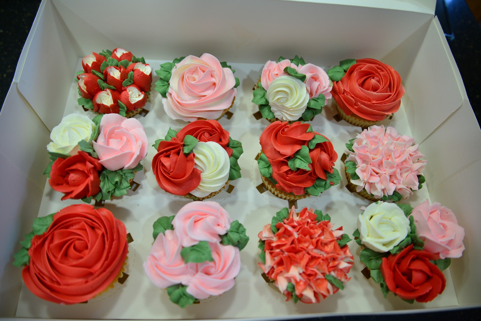 Birthday cupcakes decorated with pretty flowers.